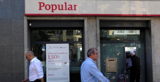 Varios transeuntes pasan junto a una oficina del Banco Popular en Madrid. REUTERS/Juan Medin