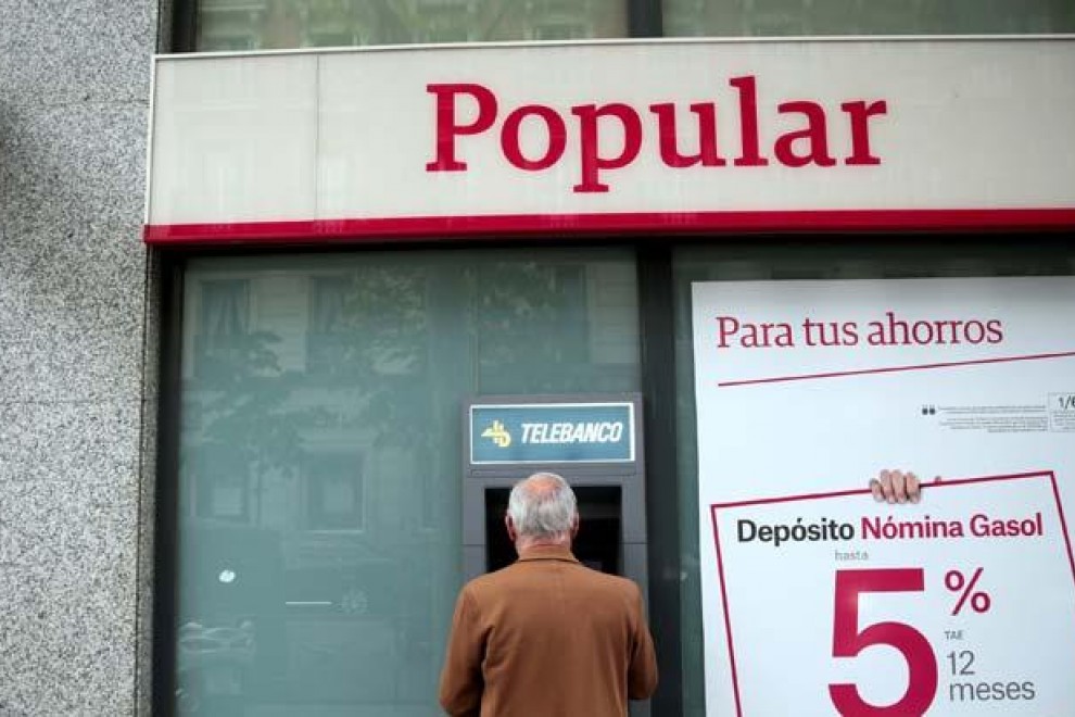 Un hombre retira dinero de un cajero de una sucursal del Banco Popular en Madrid. | EFE