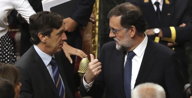 El presidente del Gobierno, Mariano Rajoy, conversa con el portavoz parlamentario del PP, Rafael Hernando, tras la votación de la moción de censura. EFE/Ballesteros