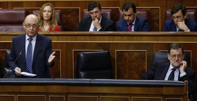 El ministro de Hacienda, Cristóbal Montoro, durante su intervención en la sesión de control al Gobierno hoy el Congreso de los Diputados.A la derecha, el presidente del Gobierno, Mariano Rajoy. EFE/Kiko Huesca