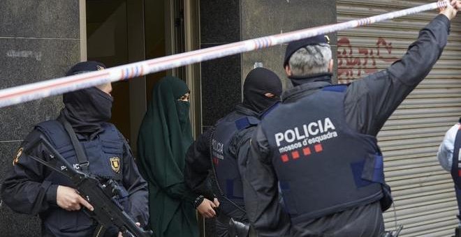Agentes de los Mossos d'Esquadra detienen a una joven en el marco de una operación contra el terrorismo yihadista. ALEJANDRO GARCIA (EFE)