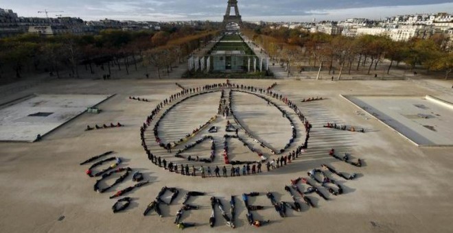 Activistas medioambientales forman el símbolo de la paz cerca de la Torre Eiffel en París, en diciembre de 2015, durante la celebración de la Cumbre del Clima en la capital francesa. REUTERS