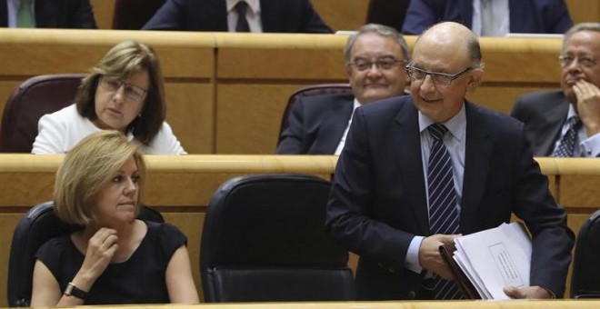 El ministro de Hacienda, Cristóbal Montoro y la titular de Defensa, María Dolores de Cospedal, durante la sesión de control al Gobierno en el pleno del Senado. /EFE