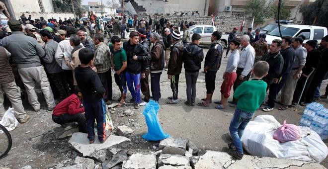 Civiles reciben paquetes de ayuda humanitaria de una organización humanitaria chií en el distrito de Al Guizlane, mientras continúa la batalla en Mosul REUTERS/Youssef Boudlal