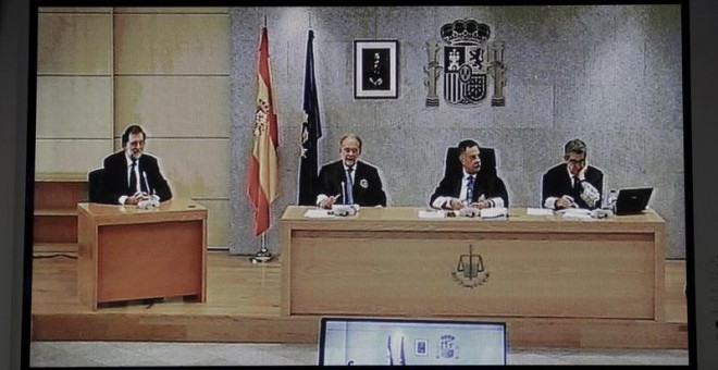Imagen del monitor de la sala de prensa de la Audiencia Nacional de San Fernando de Henares del presidente del Gobierno, Mariano Rajoy (i). /EFE