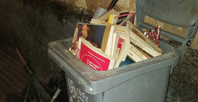 Montones de libros en un contenedor de basura