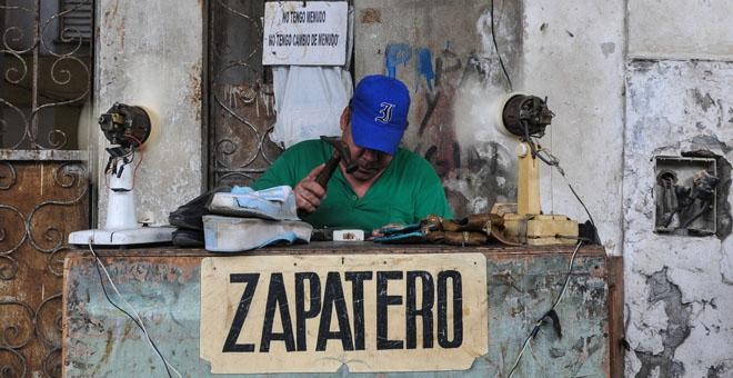 Un zapatero privado trabaja en la calle en La Habana /AFP (Yamil LAGE)