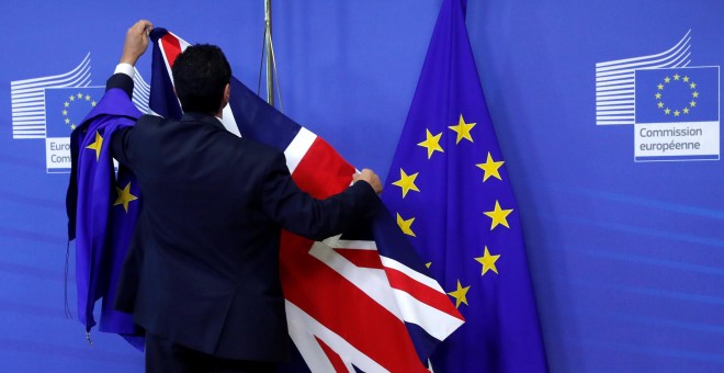 Un empleado de la Comisión Europea coloca las banderas de la UE y del Reino Unido en la sede de institución comunitaria con motivo de la primera reunión para la negociación del Brexit, el pasado 17 de julio, en Bruselas. REUTERS/Yves Herman