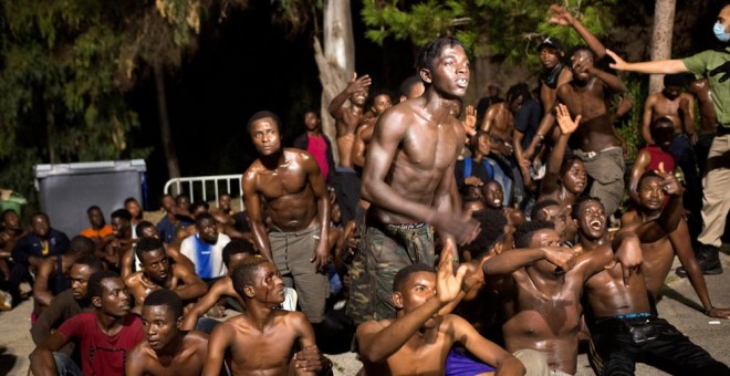 Migrantes en la madrugada de este lunes tras cruzar la frontera del Tarajal entre Marruecos y España. REUTERS