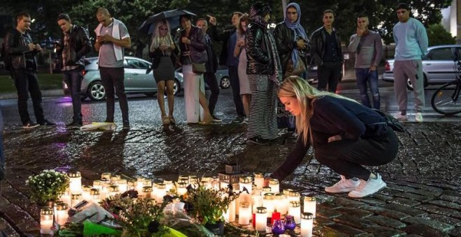 Gente coloca velas en el lugar del ataque. EFE