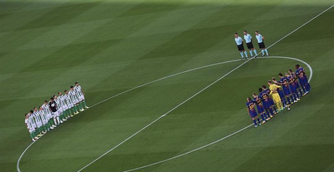 Los jugadores del Betis y del Barcelona guardan un minuto de silencio por las víctimas del atentado terrorista de Barcelona y Cambrils antes del inicio del partido correspondiente a la primera jornada de LaLiga Santander que se disputa en el Camp Nou. EFE