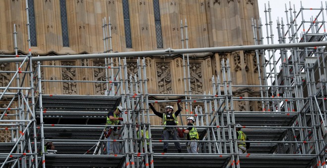 Unos trabajadores instalan los andamios que van a cubrir la Elizabeth Tower del Parlamento británico, donde está el reloj 'Big Ben', que va a permanecder parado cuatro años por obras de restauración.. REUTERS/Peter Nicholls