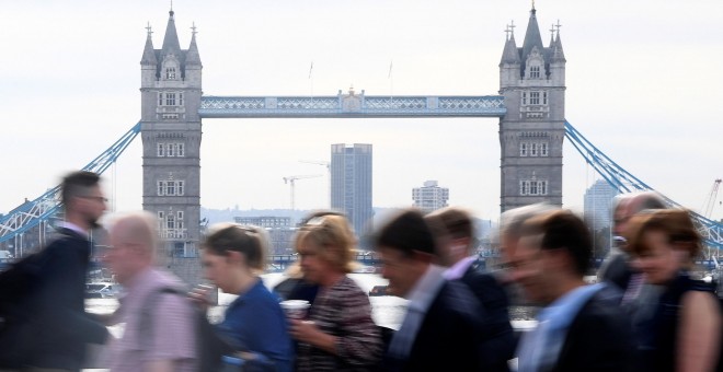 Trabajadores cruzan junto al Puente de Londres, en la hora punta por la mañana. REUTERS/Toby Melville