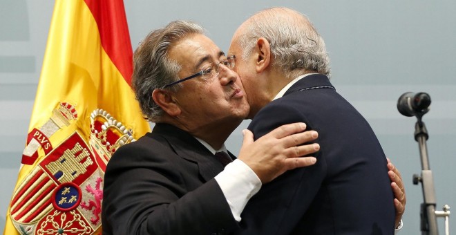 Zoido se abraza a su antecesor en el cargo, Fernández Díaz. | EFE