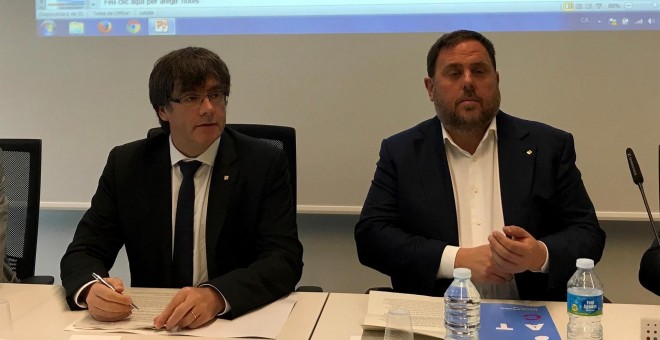 El president del Govern, Carles Puigdemont, y el vicepresidente, Oriol Junqueras, durante la rueda de prensa para presentar el despliegue de la Agencia Tributaria de Cataluña este lunes. EUROPA PRESS