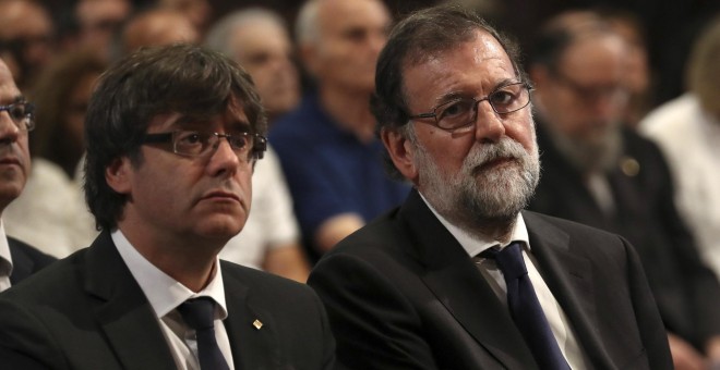 El president de la Generalitat de Catalunya, Carles Puigdemont, junto al presidente del Gobierno, Mariano Rajoy, en la misa por las víctimas de los atentados de Las Ramblas y Cambrils en la Basílica de la Sagrada Familia, en Barcelona. REUTERS/Sergio Barr