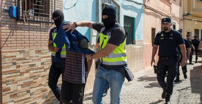Agentes de la policía llevan detenido a uno de los sospechosos de participar en una red yihadista, en Melilla. REUTERS/Jesus Blasco de Avellaneda