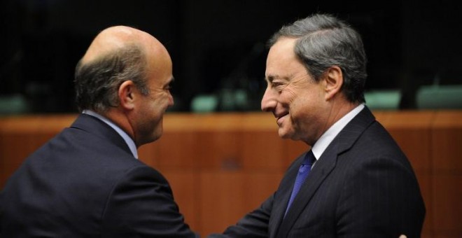 El ministro de Economía, Luis de Guindos, con el presidente del BCE, Mario Draghi, en una reunión del Eurogrupo en Bruselas. AFP