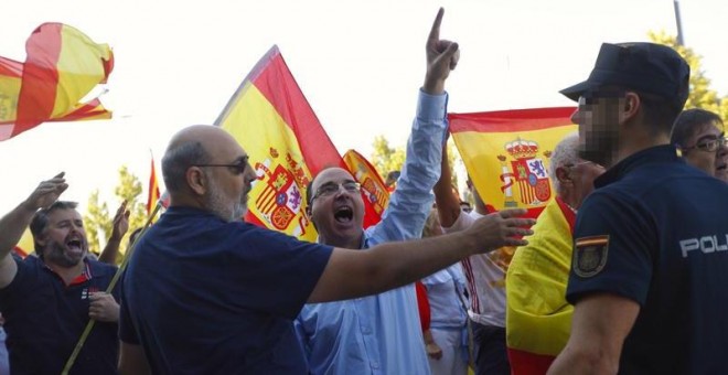 Un grupo de ultras, con banderas de España, increpan a los miembros de Unidos Podemos a las puertas de su asamblea en Zaragoza. /EFE