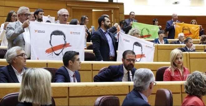Los senadores de PDeCAT y ERC exhiben banderas con la inscripción 'Democracia'. / EP