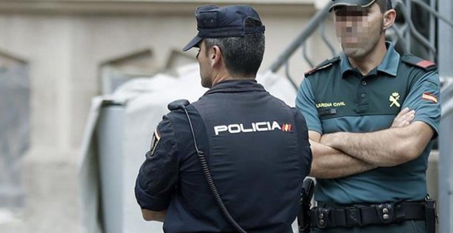 Un mosso, un policía nacional y un guardia civil vigilan el exterior del edificio de la Delegación del Gobierno en Catalunya, durante la reunión de coordinación de los cuerpos de seguridad sobre el 1-O. EFE/Andreu Dalmau