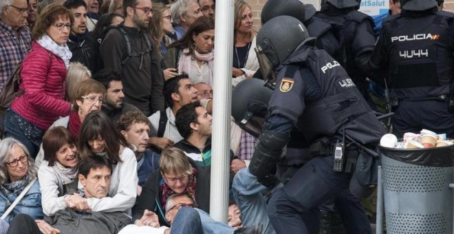 La Policía Nacional que ha requisado las urnas en el ambulatorio del barrio leridano de Cappont forcejea con unos ciudadanos . Las sedes de los centros de votación del 1-O en la ciudad de Lleida están viviendo una mañana protagonizada por la incertidumbre