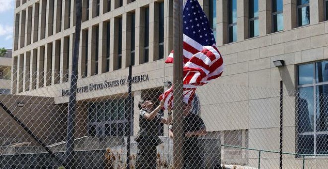 Marines estadounidenses levantan la bandera de Estados Unidos a media personal de la Embajada en La Habana / REUTERS