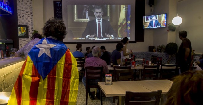 Varias personas miran el discurso del rey Felipe VI en un bar en Barcelona, al final de la jornada de paro general en protesta por la actuación policial durante el referéndum del 1-O. EFE/Quique García