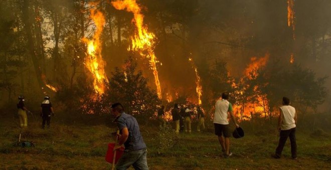 Un grupo de personas tratan de apagar el incendio de Zamanes, Vigo. EFE/Salvador Sas