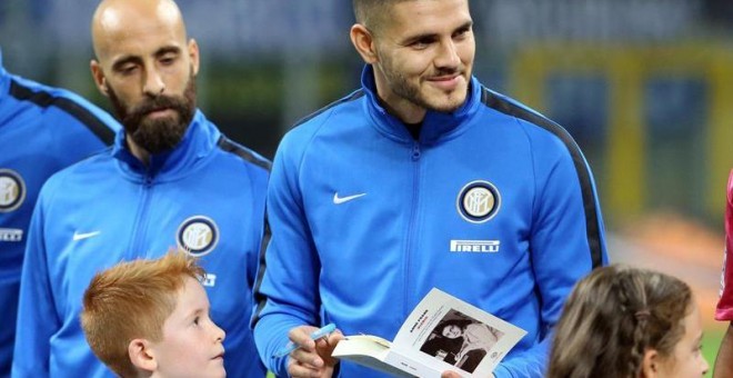El capitán del Inter de Milán, Mauro Icardi, firma una copia de 'El diario de Ana Frank' para un niño antes de un partido de la Serie A italiana entre el Inter de Milán y el UC Sampdoria. /EFE