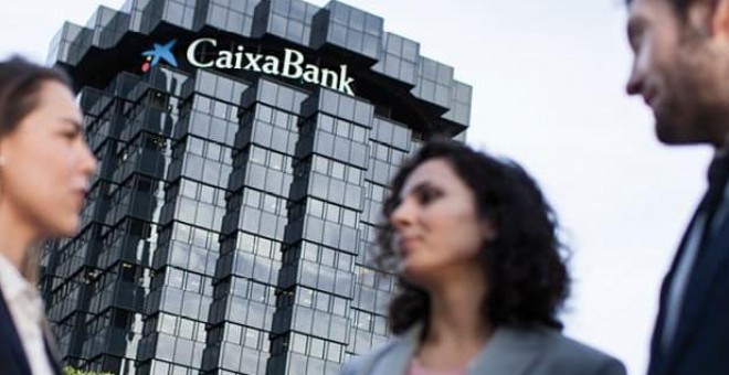 Tres empleados delante de un edificio de CaixaBank.