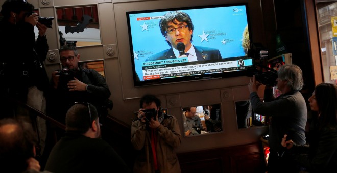 El televisor de un bar de Barcelona emite la rueda de prensa de Carles Puigdemont que ofreció desde Bruselas. - REUTERS