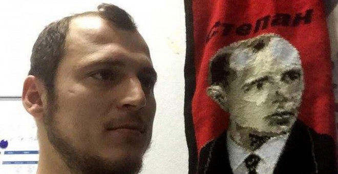 Román Zozulya, posando junto a un estandarte con la imagen de Stepán Bandera