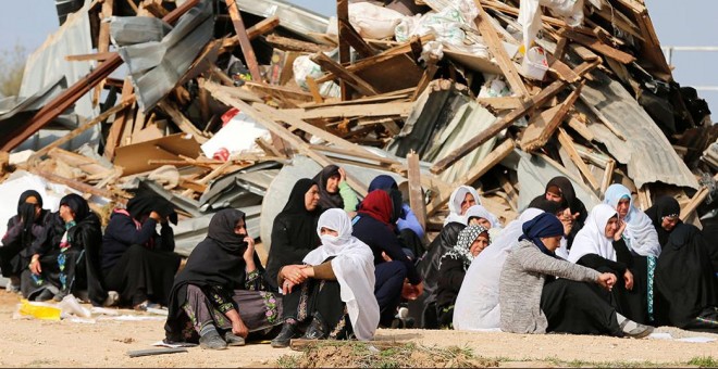 Mujeres sentadas ante sus hogares demolidos en el pueblo beduino de Umm al-Hiran, en el desierto israelí de Negev. / REUTERS