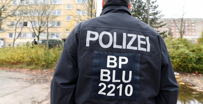 Un agente de la policía alemana frente a un edificio residencial en Schwerin. / Reuters
