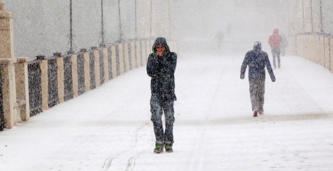 Varias personas entre la nieve en una calle de Teruel. EFE