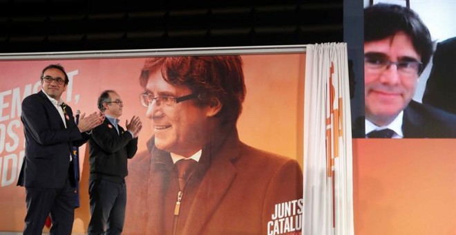 Los exconsellers y candidatos de JxSí Jordi Turull y Josep Rull (i) hablan por videoconferencia con el expresidente Puigdemont durante la rueda de prensa que han ofrecido después de salir de prisión. EFE/Toni Albir