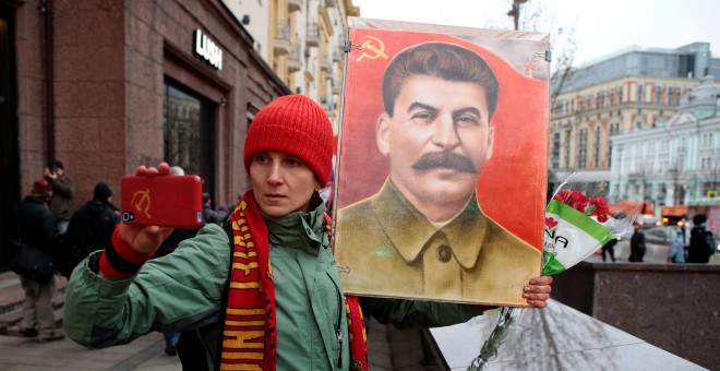 Un hombre se fotografía junto a un retrato de Stalin./REUTERS