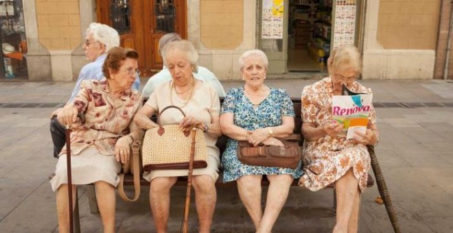 Cuatro mujeres mayores sentadas en un banco una plaza de Barcelona. AFP