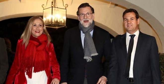 El presidente del Gobierno y del PP, Mariano Rajoy, junto a la presidenta de la Comunidad, Cristina Cifuentes (i), y el alcalde de Las Rozas, José de la Uz (d), a su llegada a la cena de navidad del PP de Madrid, hoy en Las Rozas. EFE/Mariscal