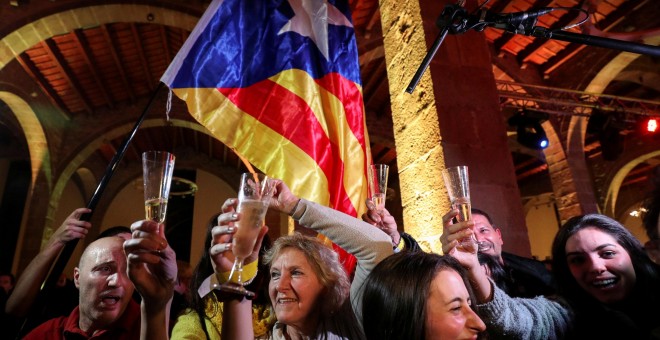 Varias personas celebran los resultados de las elecciones del 21-D en la sede de la Asamblea Nacional Catalana (ANC) en Barcelona. REUTERS / Albert Gea