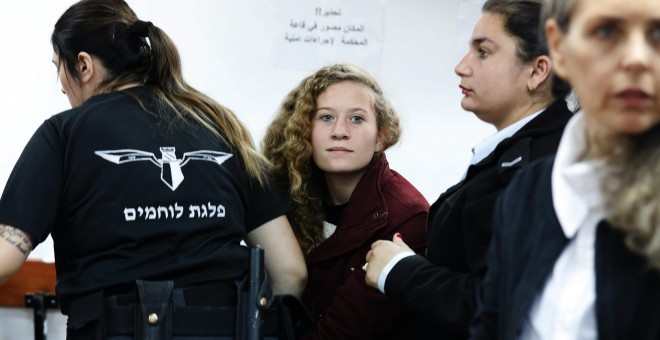 La adolescente palestina  Ahed Tamimi, es escoltada por agentes de la policía israelí hacia un juzgado en la localidad de Betunia (Palestina). EFE/ Abir Sultan