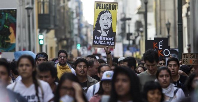 Manifestantes participan con banderas y pancartas durante una marcha contra el indulto otorgado a Alberto Fujimori en Lima. - EFE