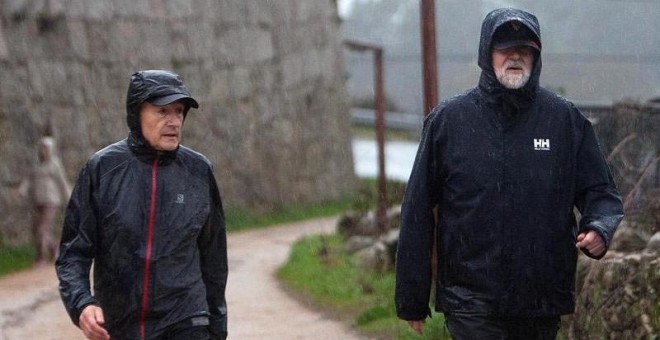 Mariano Rajoy, a la derecha de la imagen, camina bajo la lluvia acompañado del marido de Ana Pastor. |  SALVADOR SAS (EFE)