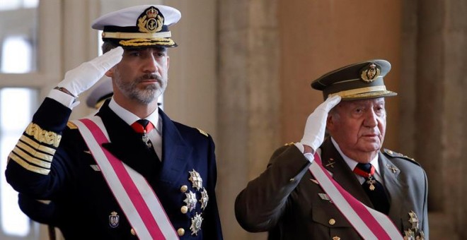 El Rey Felipe VI y el Rey emérito Juan Carlos, escuchan el himno nacional, a su llegada a la celebración hoy de la Pascua Militar en el Palacio Real. / EFE