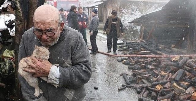 Anciano abrazando al gato superviviente tras el incendio de su casa. Facebook / NTV Radyo