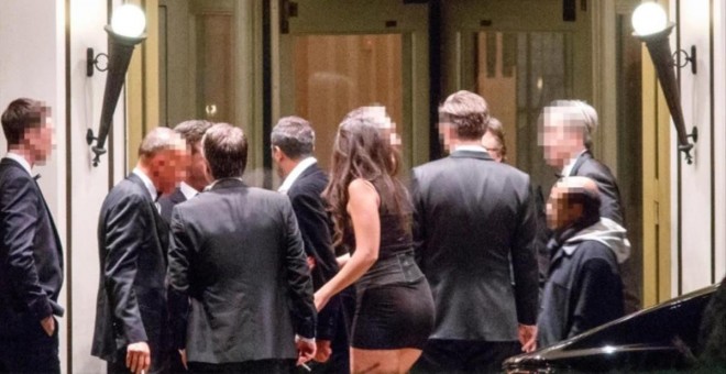 Fotografía del 'Financial Times' en la que se puede ver a una de las jóvenes contratadas junto a varios invitados en la puerta del hotel donde se celebró la cena machista en Londres. FT/Tolga Akmen