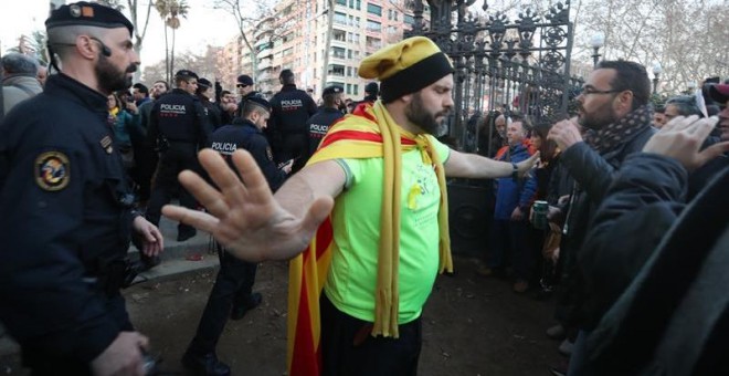 Un hombre se interpone entre los Mossos D'esquadra y los manifestantes durante las protestas frente al Parlament. EFE/Toni Albir