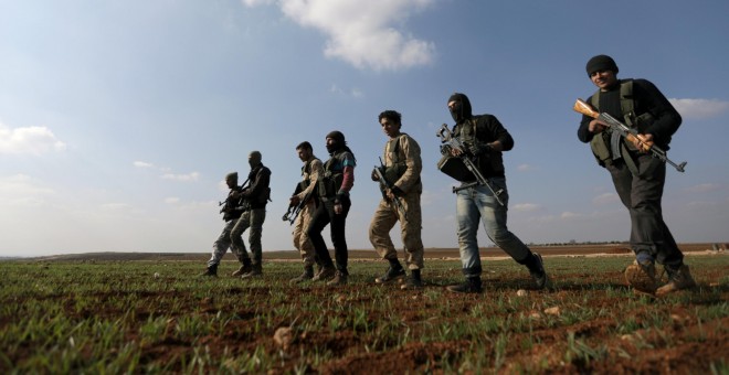 Combatientes kurdos que luchan junto con el Ejército Sirio Libre, caminan juntos en el norte de la campiña de Alepo. REUTERS / Khalil Ashawi