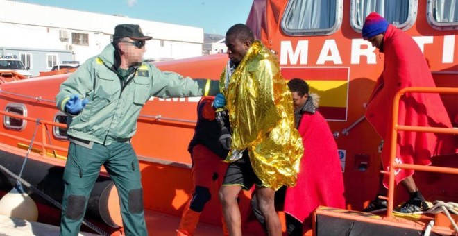 Un agente de la Guardia Civil ayudando a los 36 inmigrantes de origen subsahariano que viajaban en una patera y que han sido rescatados a 11 millas de la isla de Alborán por Salvamento Marítimo. EFE/Alba Feixas